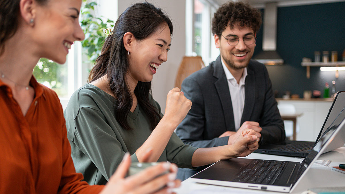 Happy business people working on a laptop together