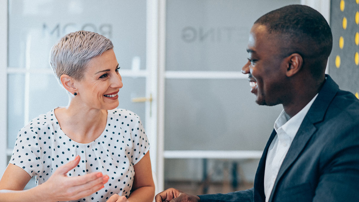 Mature business woman talking to a black man