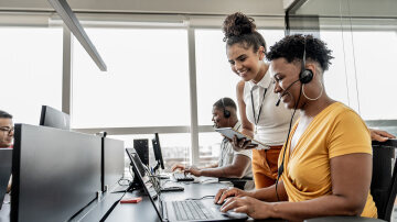 Business woman providing support to employee with a headset