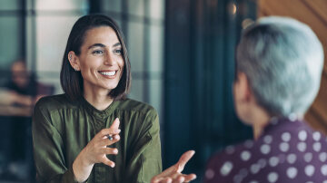 Business woman talking to an employee with a smile on her face