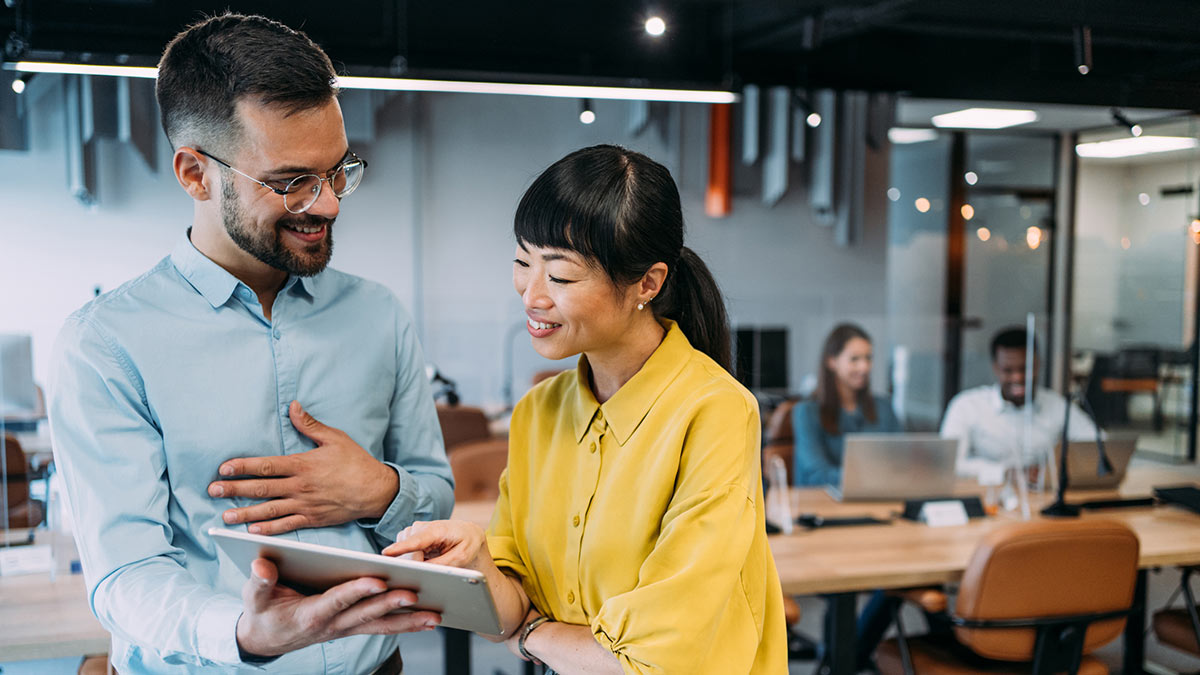 Two coworkers having a discussion in modern office