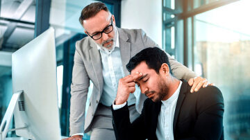 Business man comforting an employee