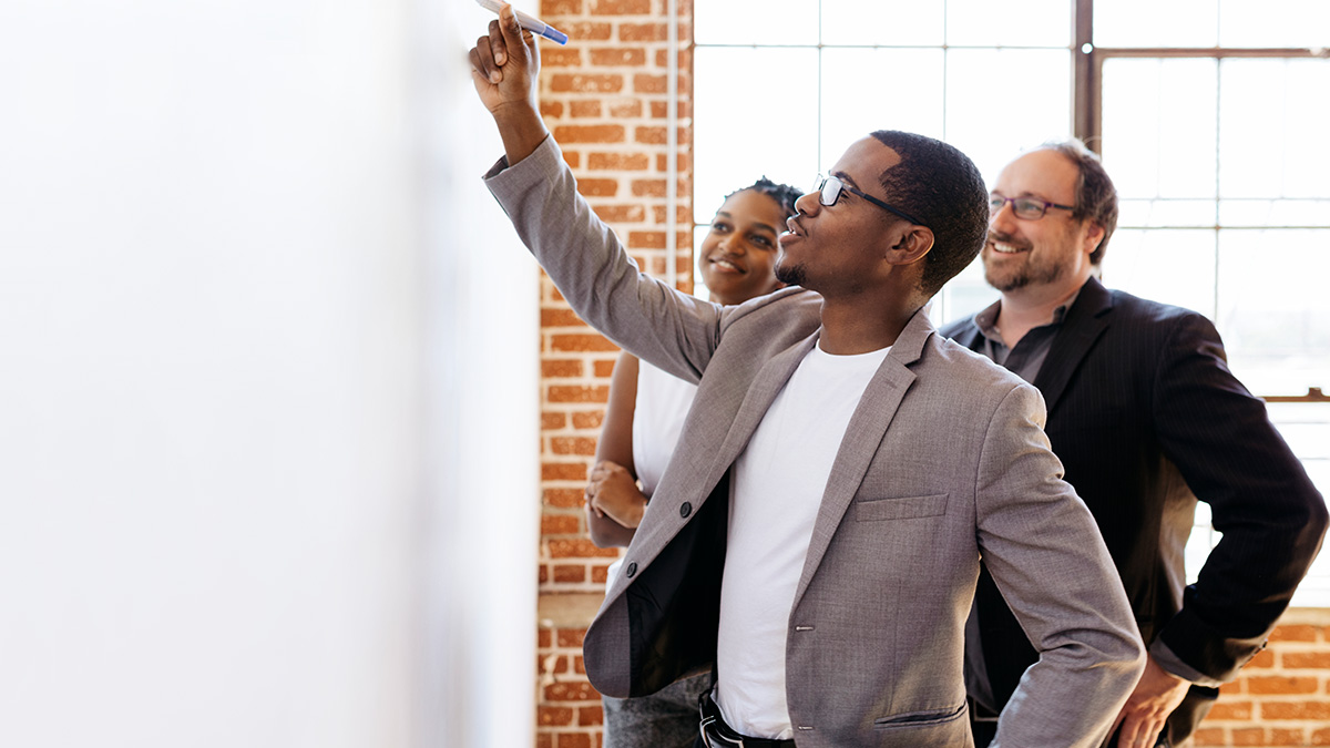 Group of business people writing on a board