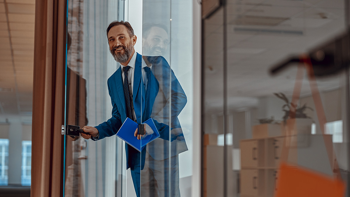 Businessman stepping through a glass door