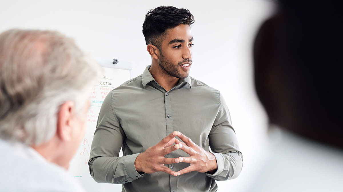 Brown skinned businessman talking to team members