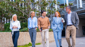 Group of business people walking in a row talking