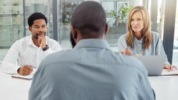 Two people interviewing a third person