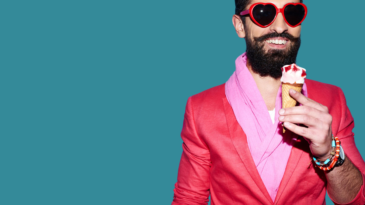 Man in a pink suit smiling whilst eating icecream