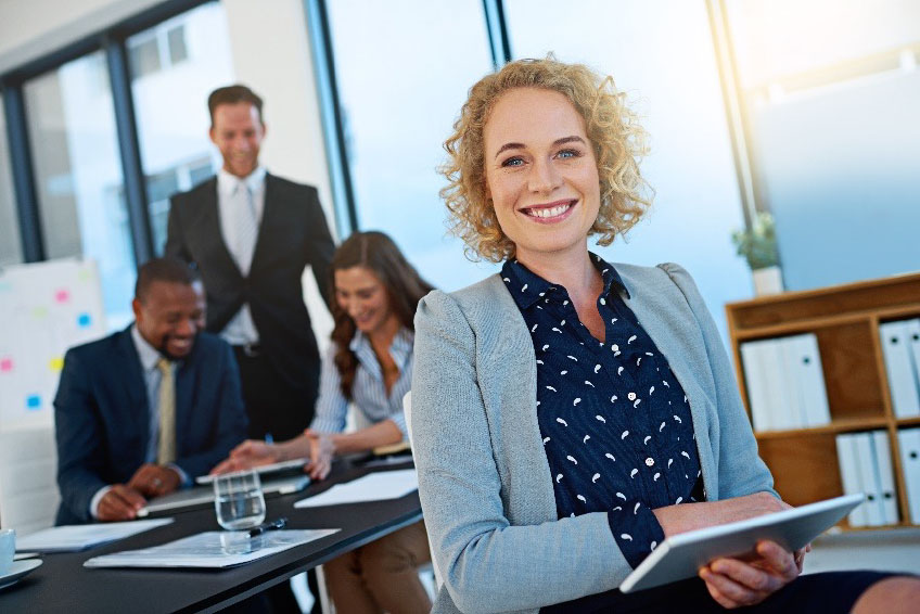 Smiling business woman with business people in the background